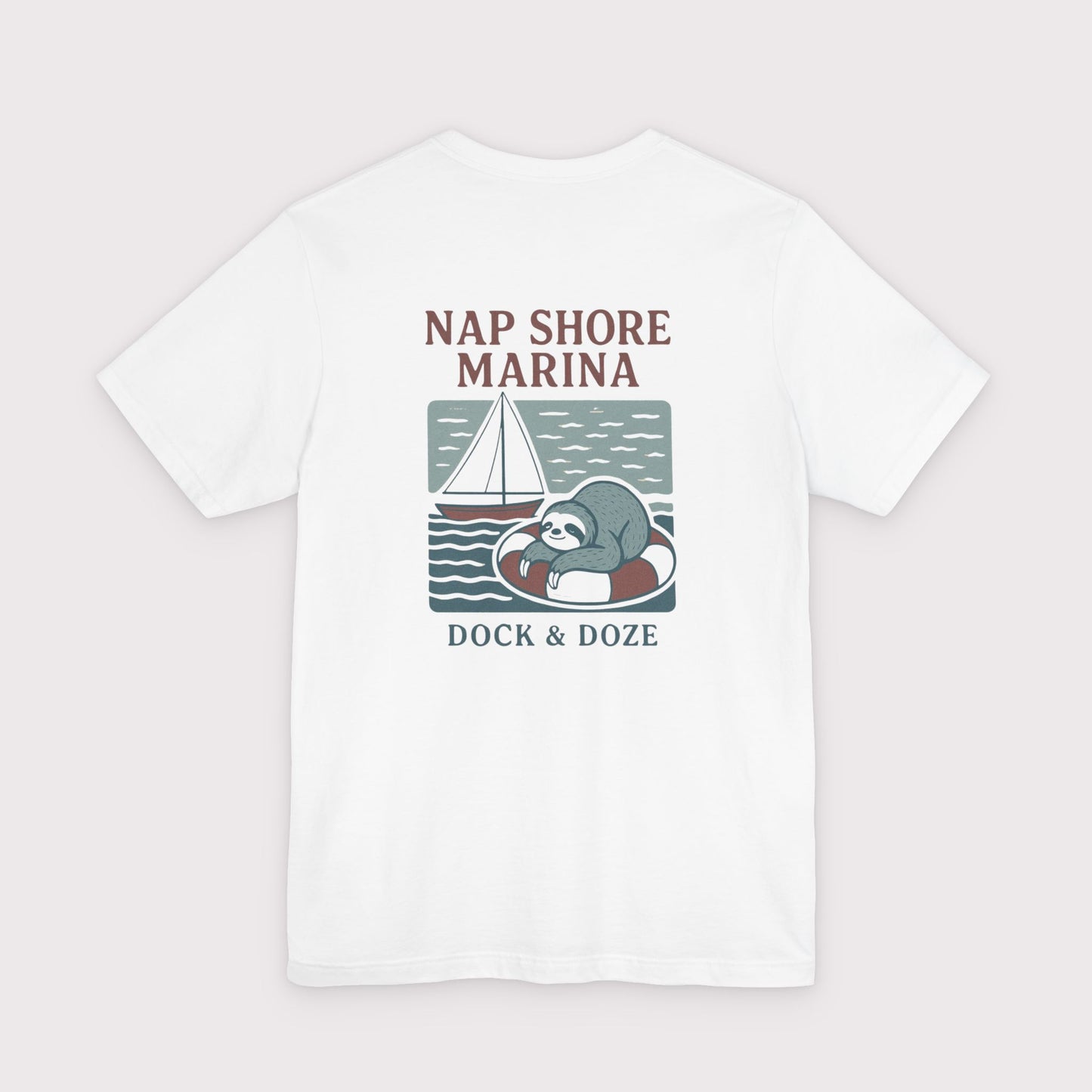 White t-shirt with a sloth graphic and text 'Nap Shore Marina' on a light gray background